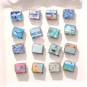Dettaglio di charms in acciaio inossidabile a tema marino con balene e stelle marine in smalto