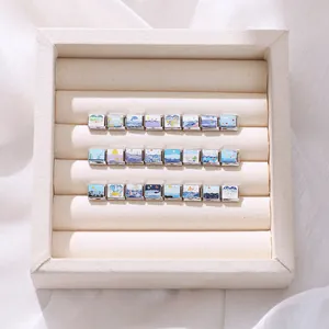 Detailed close-up of 24 Italian style charms with ocean and wave enamel patterns