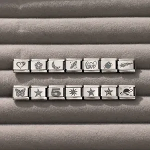 Macro view of modular Italian charm links in silver stainless steel with various icons
