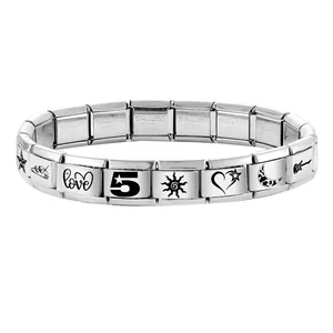 Detailed macro view of modular stainless steel charm bracelet with engraved vintage icons