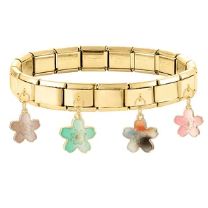 Gros plan sur un bracelet italien doré avec quatre breloques de cerisier en émail coloré
