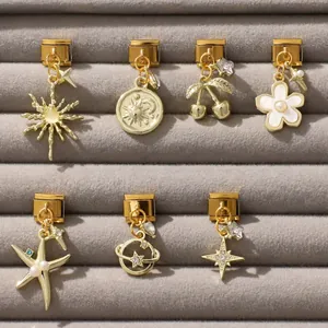 Detailansicht goldener modularer Italian Charms mit Sonnen-, Mond- und Blumen-Emaille-Dekor