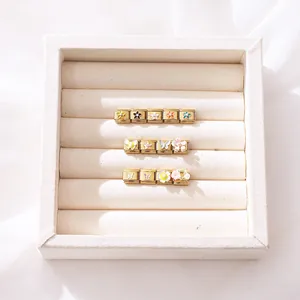 Detailansicht von italienischen Charms mit bunten Emaille-Blumen und Schmetterlingen