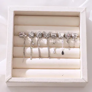 Detail shot of silver charms with pink zircons and pearls in a soft velvet jewelry box