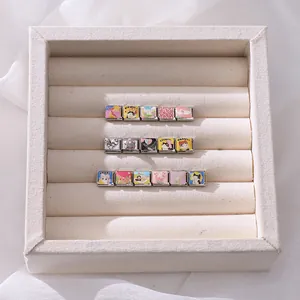 Detail of DIY Italian charms with enamel cats, hearts, and lucky icons in a jewelry box