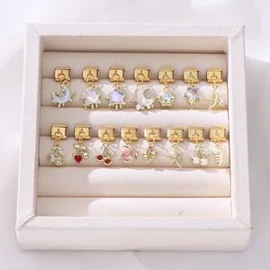 Detail of 15 modular gold charms with enamel and rhinestones in a velvet display box