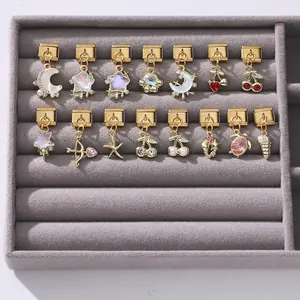 Detailed view of Italian charm pendants in gold finish with pearls and enamel motifs