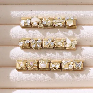 Dettaglio ravvicinato di charm italiani in oro con perle e smalto in una scatola portagioie