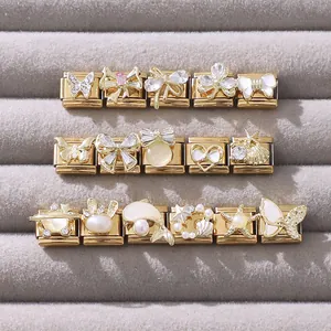 Selezione dettagliata di charm dorati con zirconi rosa e perle su velluto grigio