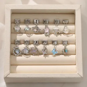 Detailed view of Italian charm links with space and sea themes on a beige display tray