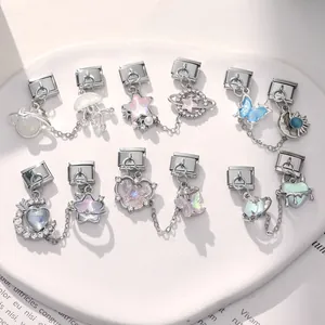 Close-up of Italian charm bracelet links with moon, star, and butterfly charms in steel