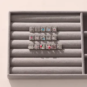 Détails des charms en acier inoxydable avec zircons colorés et incrustations de pierres