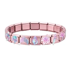 Macro detail of rose gold Italian charm bracelet with holographic sea theme charms