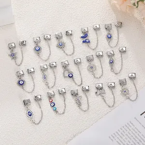 Macro shot of stainless steel evil eye charms with blue enamel and crystal details