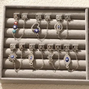 Macro detail of silver stainless steel evil eye charms with security chains for bracelets