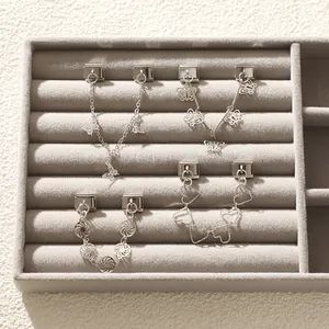 Makroaufnahme von silbernen DIY-Charms mit Schmetterlings- und Herzanhänger-Details
