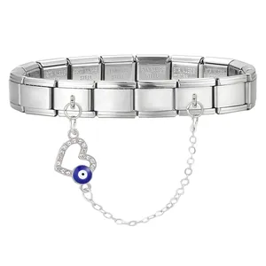 Macro detail of stainless steel modular bracelet with zircon heart and blue evil eye charm