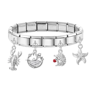 Dettaglio del bracciale modulare in acciaio con ciondoli a forma di aragosta, riccio e stella