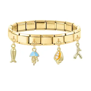Detail eines goldenen italienischen Charm-Armbands mit Meeresanhängern und Gravur-Details