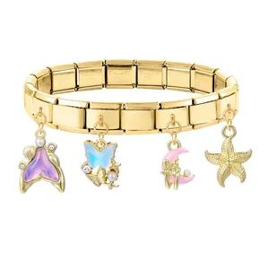 Nahaufnahme eines goldenen Italian Charm Armbands mit Meerjungfrauenschwanz und Anhängern