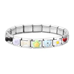 Macro shot of Italian charm bracelet links featuring colorful enamel flower and heart motifs