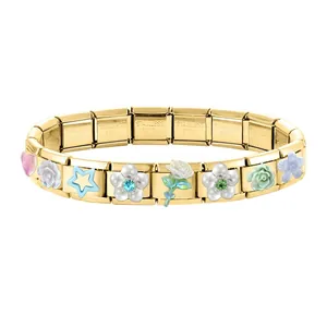 Detail des goldenen modularen Armbands mit Edelstahl-Stempeln und Blumen-Anhängern