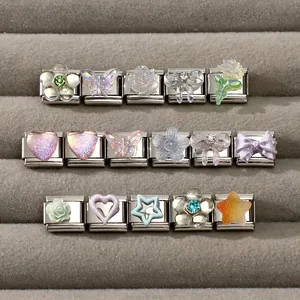 Detailed macro view of modular Italian charms featuring resin flowers and hearts on steel