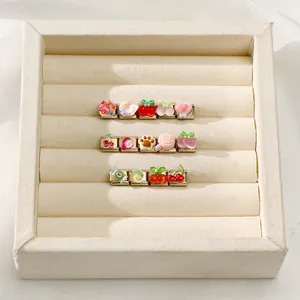 Detailed macro view of 3D resin fruit charms on gold-tone Italian bracelet links