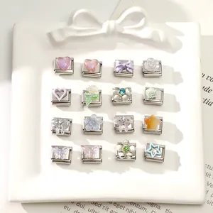 Close-up of 16 assorted Italian charm modules with resin hearts, bows, and floral patterns