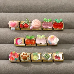 Close-up of golden Italian charm links with cute resin fruit and dessert designs