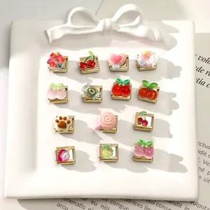 Flat lay of 15 gold-tone Italian charms with colorful fruit and candy resin icons