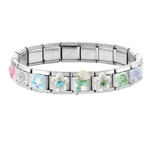Detailed macro view of stainless steel charm links with colorful floral and star patterns
