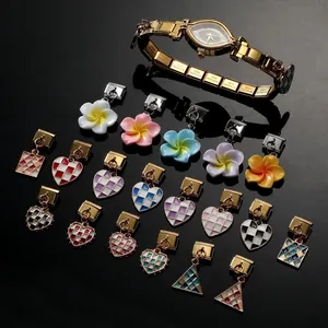 Macro shot of stainless steel gold modular watch links with colorful enamel flower charms