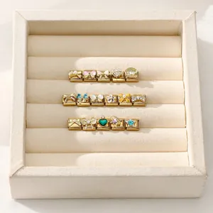 Detailed view of DIY Italian charms with colorful enamel designs in a jewelry box