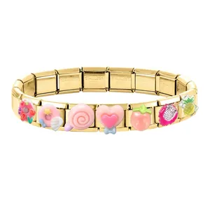 Detail of gold modular charms bracelet with resin fruit and dessert icons on stainless steel