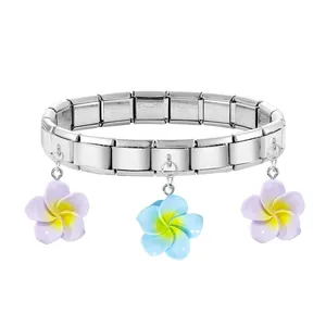 Macro detail of stainless steel modular bracelet with colorful floral pendants and engraving