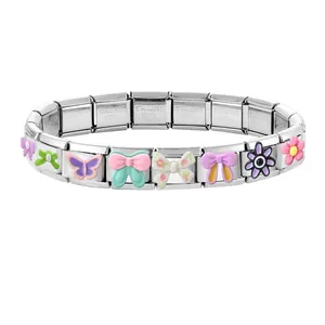 Detailed view of colorful enamel charms on a modular stainless steel chain bracelet