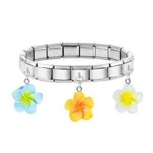 Close-up of stainless steel Italian charm bracelet with colorful plumeria flower pendants