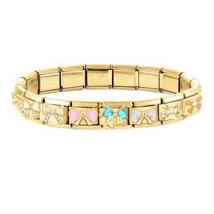 Macro detail of gold stainless steel charm links with enamel and rhinestone bows