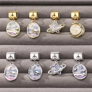 Detail of 8pcs Italian charm links in gold and silver featuring moon and star patterns