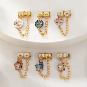 Detail goldener italienischer Charm-Armband-Elemente mit Blumen und Hausanhängern