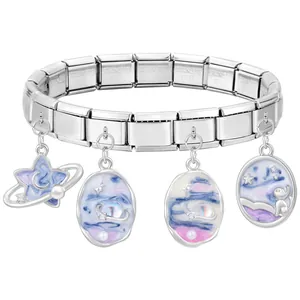 Detailed macro of stainless steel modular charm bracelet with galaxy theme pendants