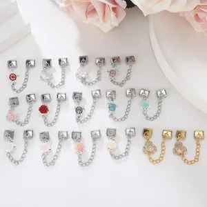 Macro detail of various rose and turtle Italian charm bracelet links in silver and gold finish