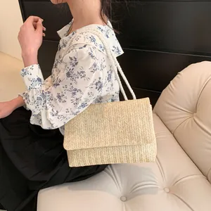 Detail of beige straw woven shoulder bag with thick cotton rope straps for a summer look