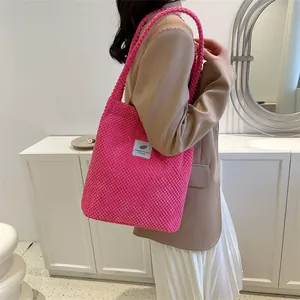 Chic magenta large tote bag with braided handles and woven texture worn by model