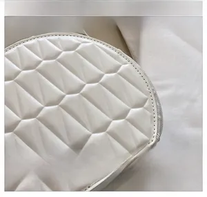 Détail du sac bandoulière blanc matelassé en similicuir avec fermeture éclair et clous de fond