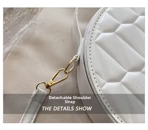 Détail de la bandoulière amovible avec crochet en métal doré sur le sac blanc