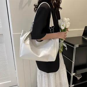 Detail of cream large tote bag with silver chain straps and premium faux leather texture