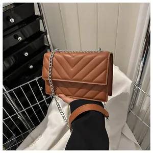 Close-up of brown chevron quilted crossbody bag featuring a silver chain strap