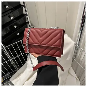 Detailed close-up of dark red V-quilted faux leather bag with elegant silver chain strap